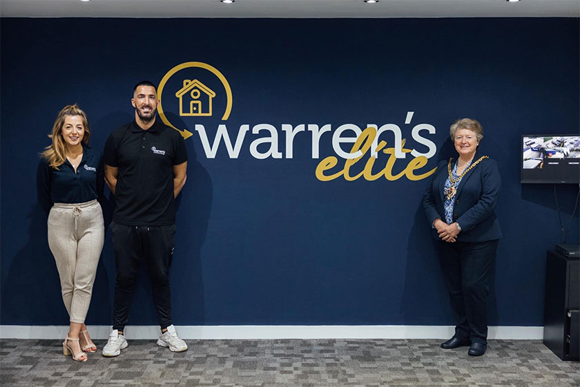 Warren's elite staff in front of Warren's elite logo